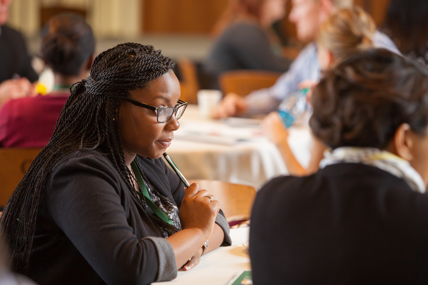 Woman sits at table at MBA conference 