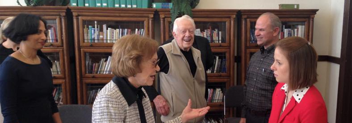 History graduate student Eryn Kane (in red) talks with Rosalynn Carter, as President Carter looks on. 