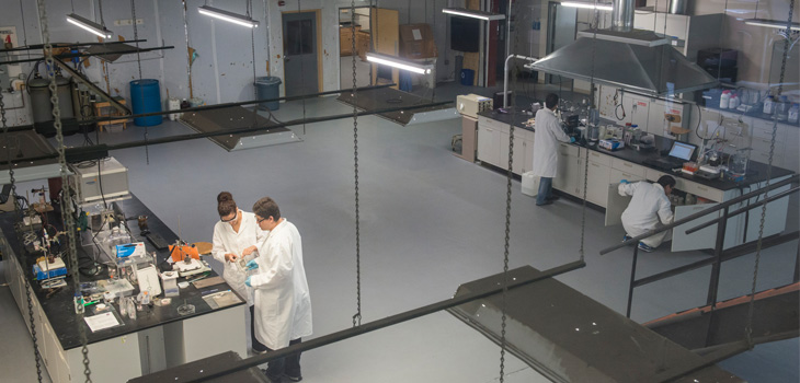 Lab in which researchers are working with equipment at two tables several meters apart