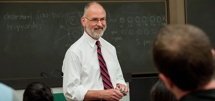 A professor smiling at his class.