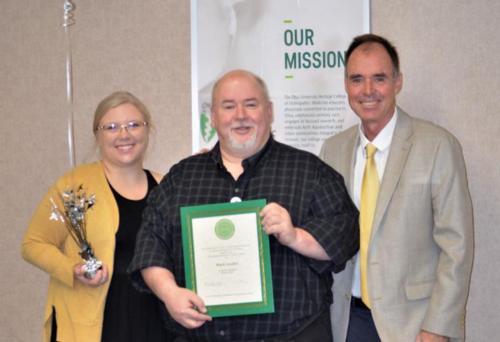 Mark Loudin holding award