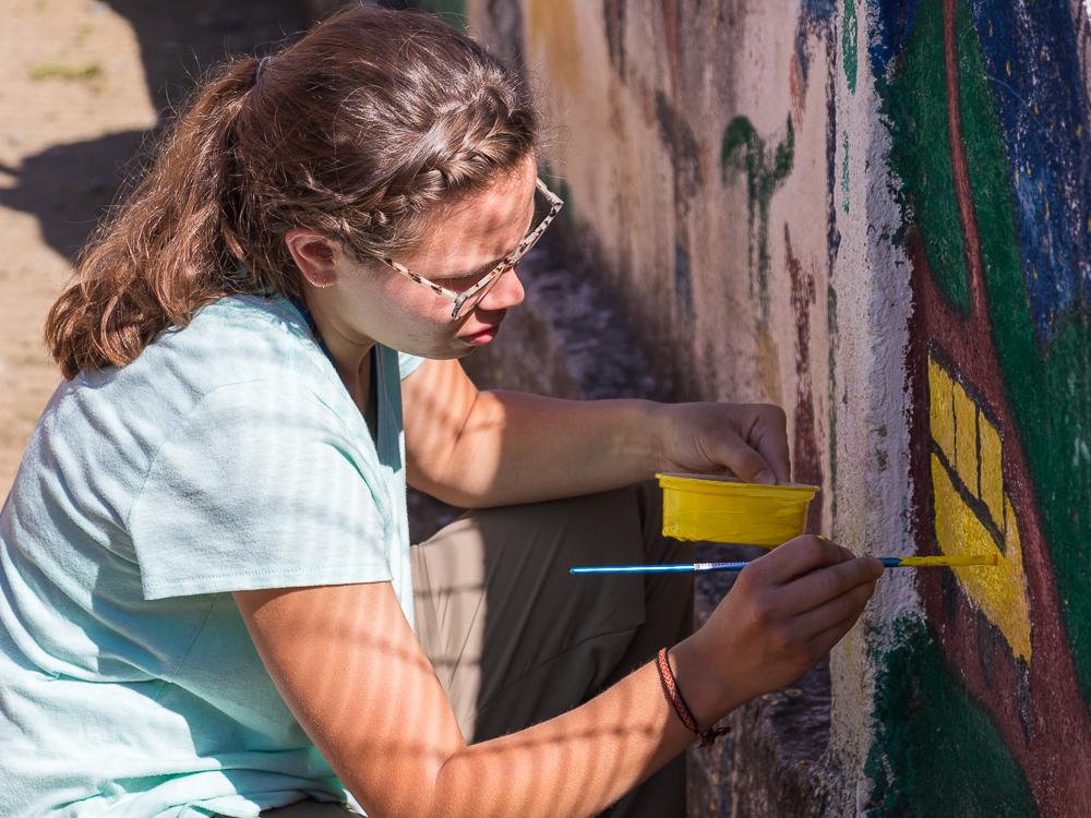 A volunteer paints a mural in Chaquizhca Community