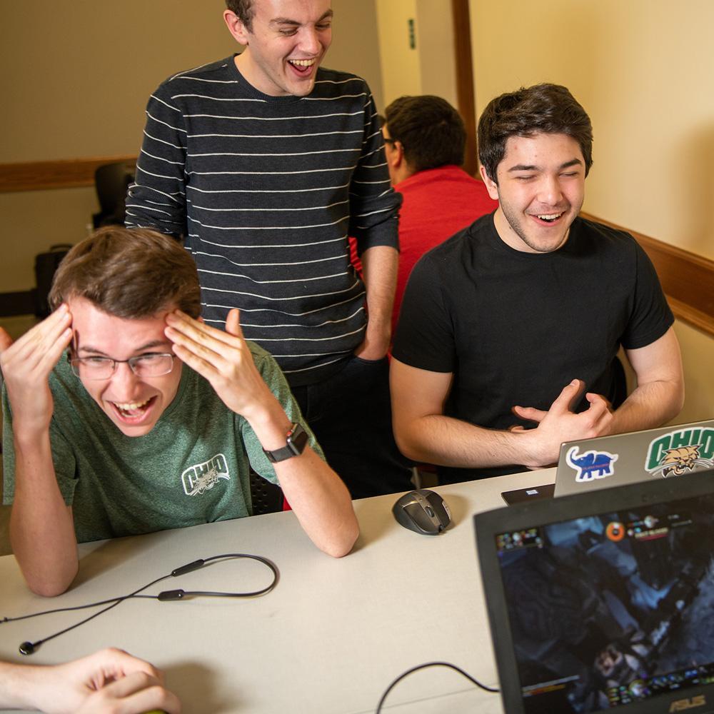 Students laugh while playing videogames