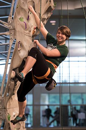 Woman climbing rock wall in Ping Rec Center