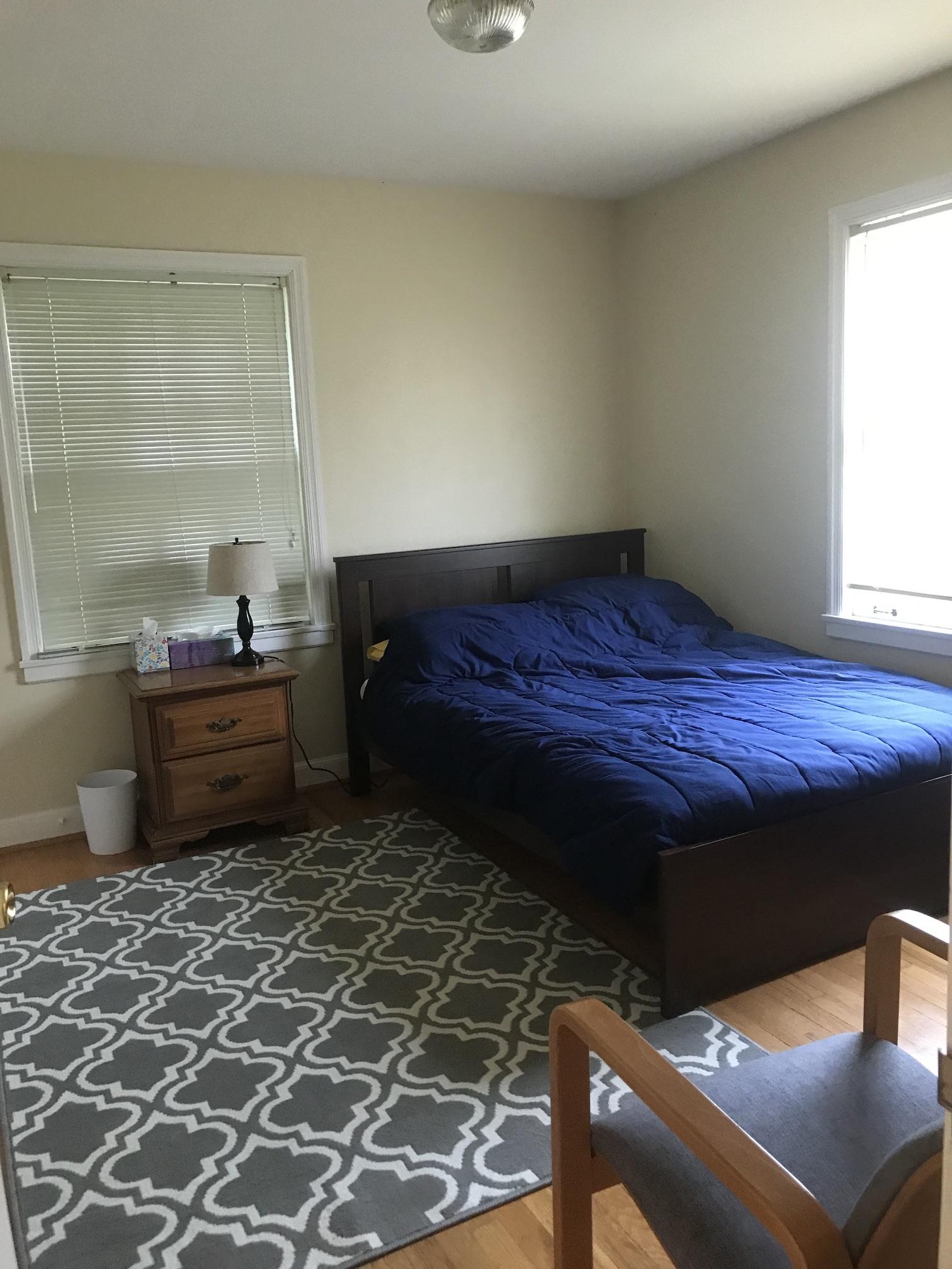 Bedroom with wood floor and windows on two walls