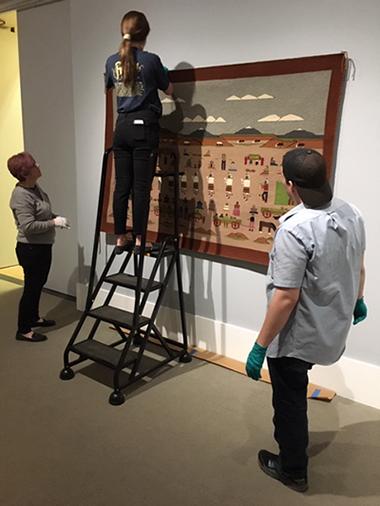 student interns installing exhibition