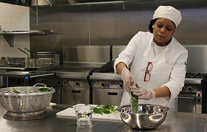 Hospitality student cooks in the kitchen.