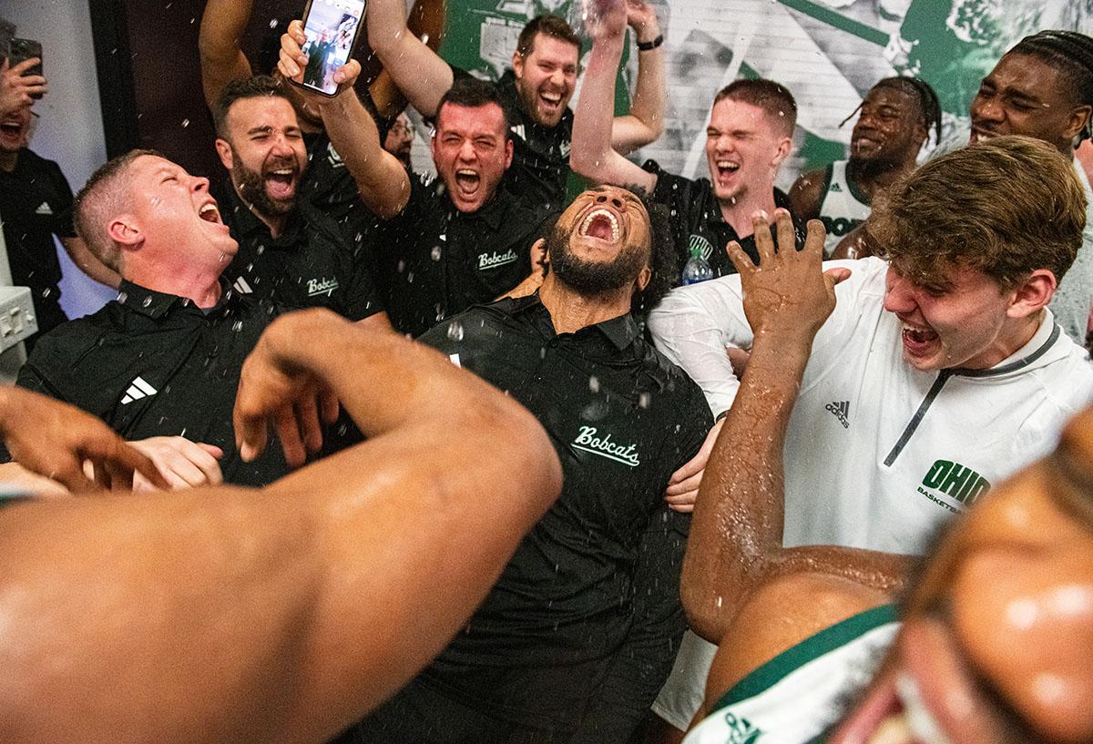 The Ohio Men’s Basketball team and coaches celebrate a comeback win over Delaware in the locker room at the Convocation Center 