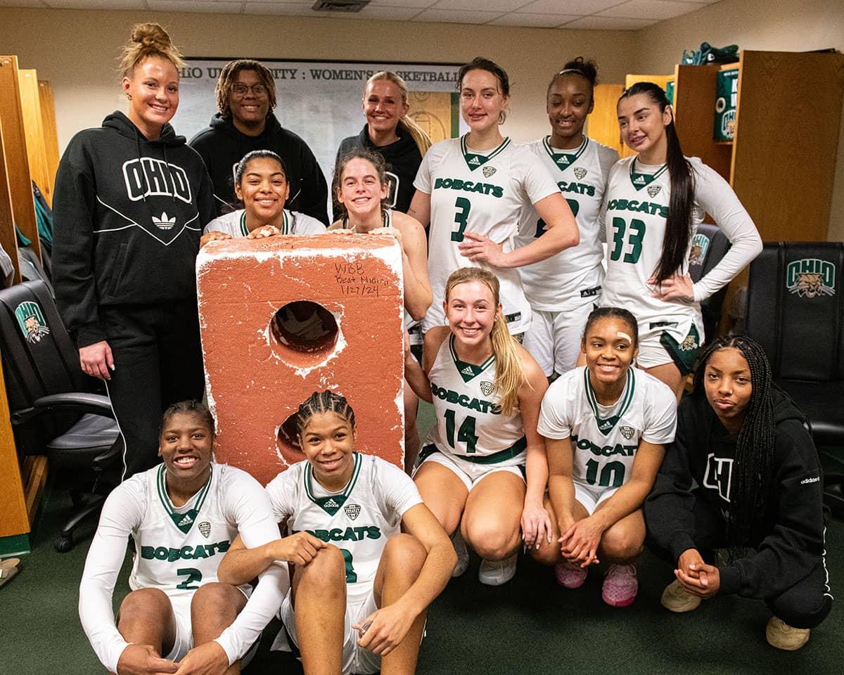 The Ohio Women’s Basketball team poses for a photo with a foam brick to celebrate a Battle of the Bricks win against Miami