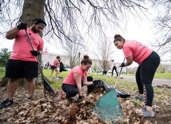 Jorge Nunez, Alexis Reed, and Briana rake and pick up leaves at the front entry of the Dairy Arts Barn during Athens Beautification Day 2018.