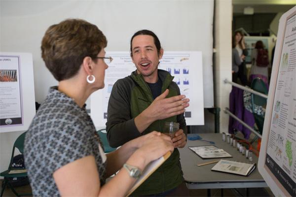 A student discusses their research during the student expo event