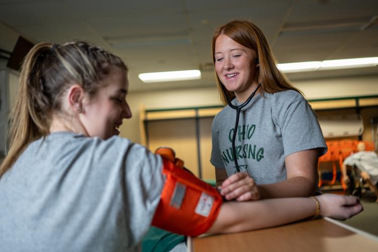 Student in blood pressure cuff