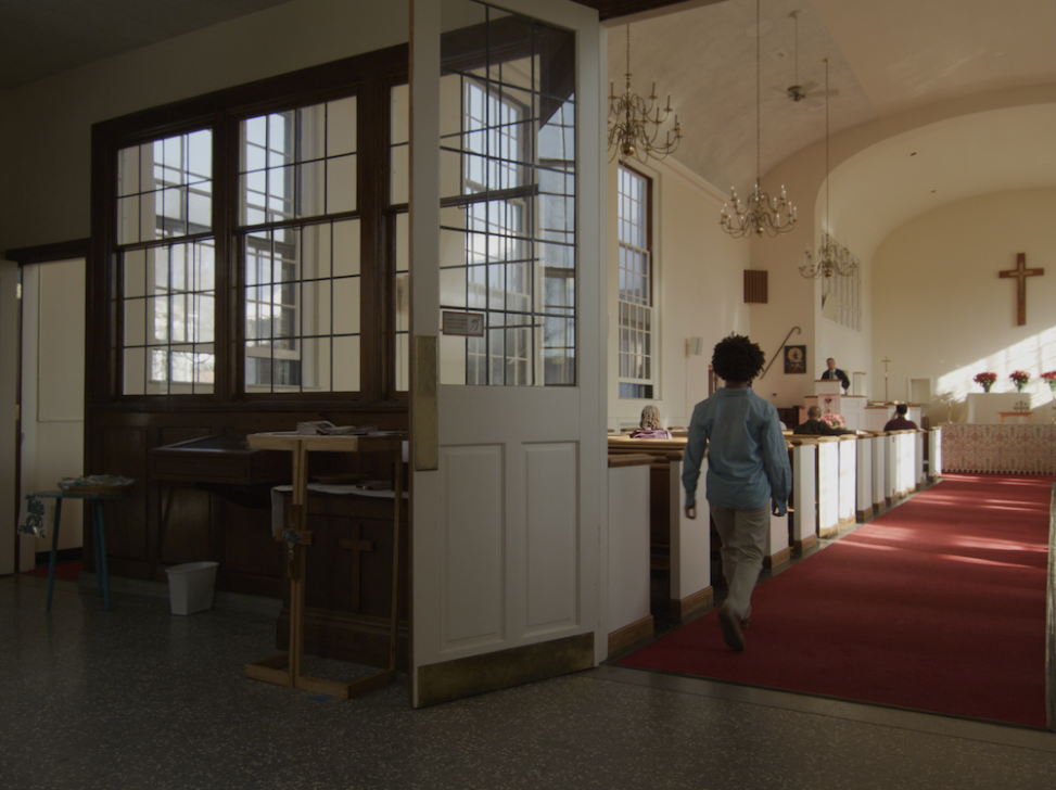 Still of Kai in the aisle of a church