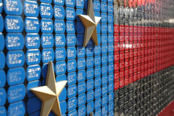 A close up image showing the dog tags and gold stars on the VAU Fallen Heroes Memorial