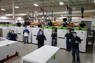 Stirling Ultracold employees stand with the company's freezers.