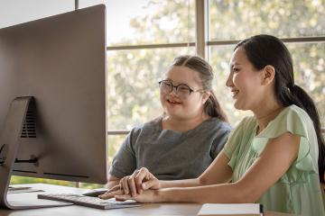 Special Education teacher working with student at a computer.