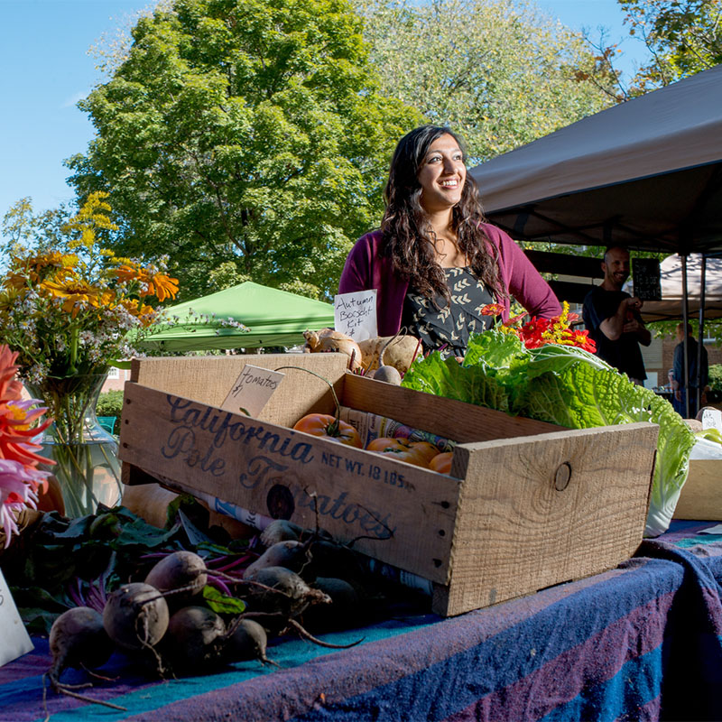 A student works at a farmer's market.