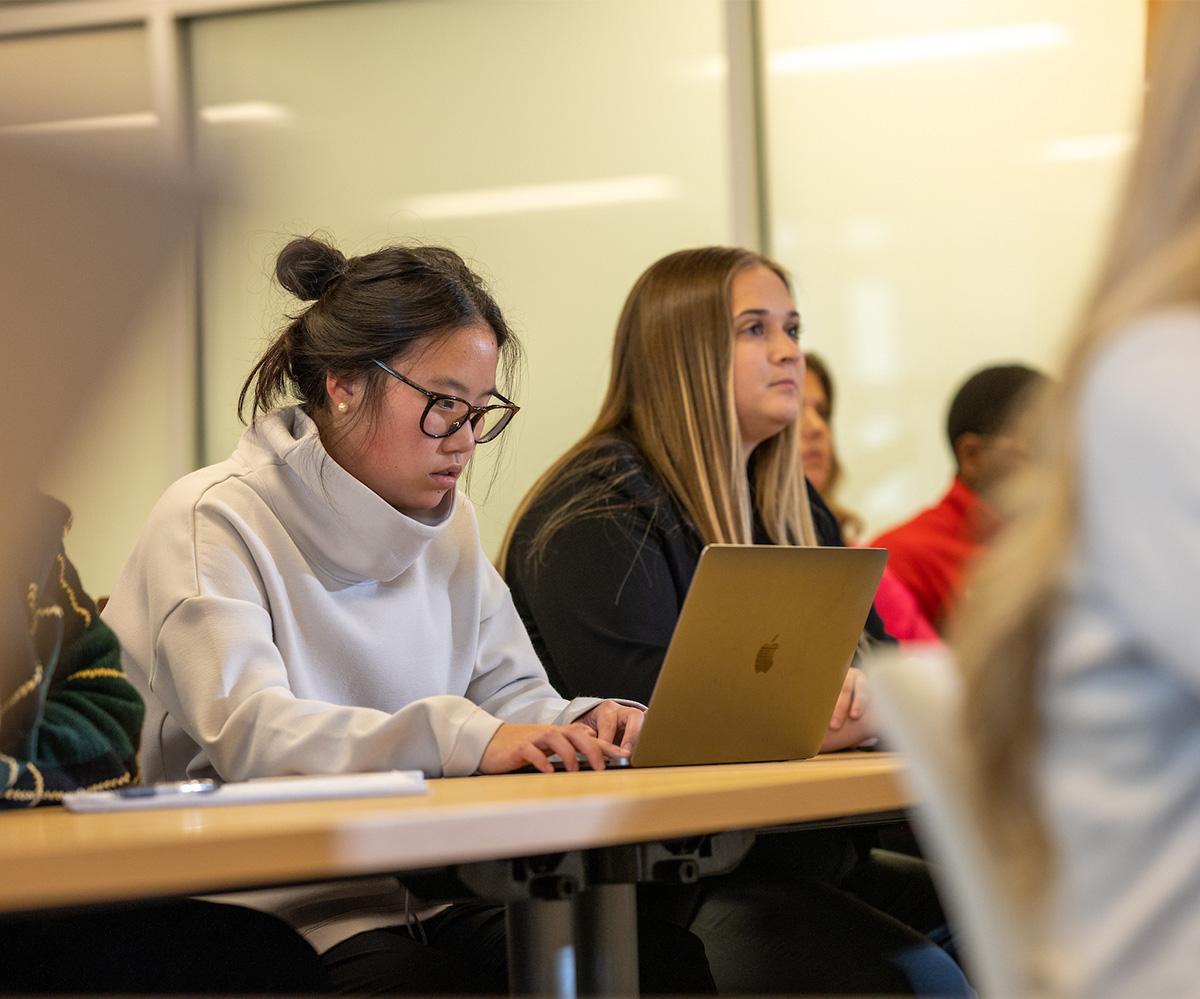 A student types on their laptop during class.