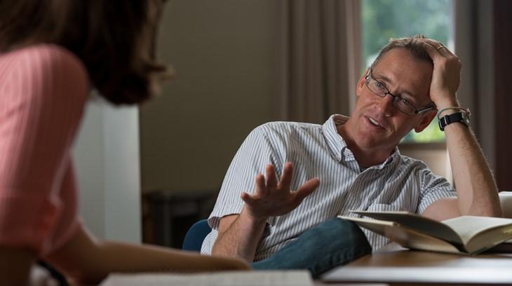 Business professor talks with a student