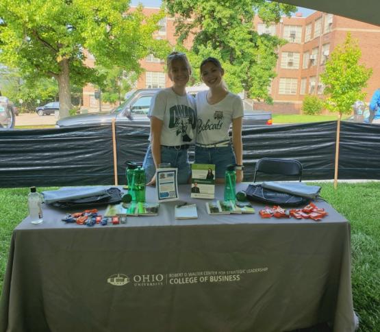 Two women standing next to a table