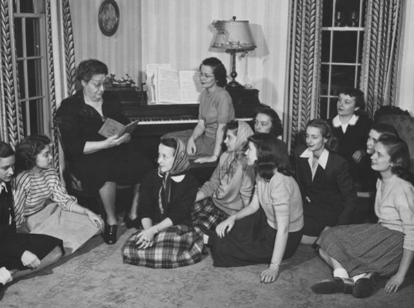 	 Irma Voigt, Ohio University dean of women, reads from book during a fireside chat with students in her home at 35 Park Place, circa 1948