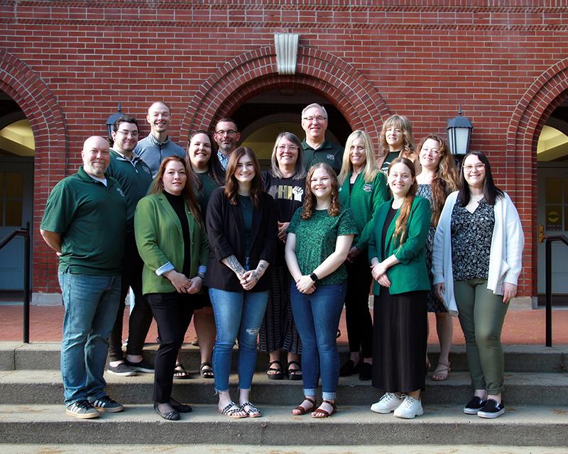 3 rows of Success Advisors posing in front of a OHIO brick building