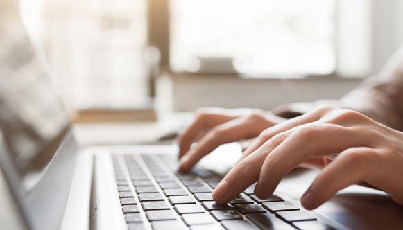 Hands typing on computer keyboard