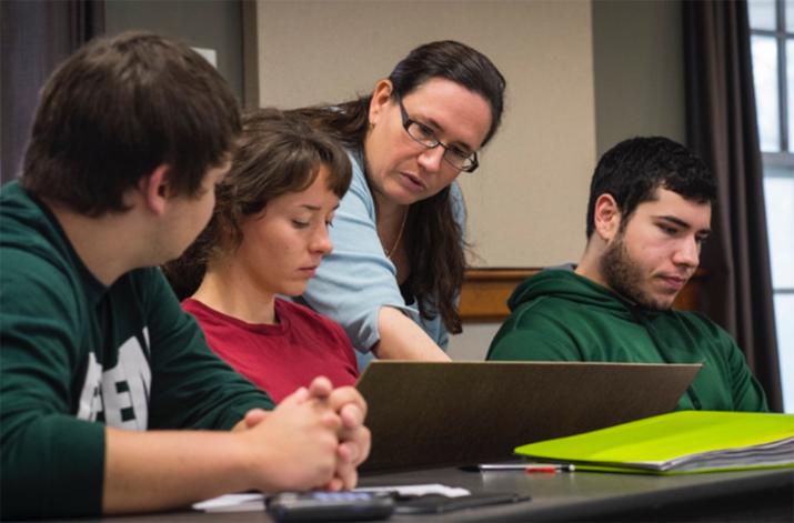 Julie Roche in classroom with three students