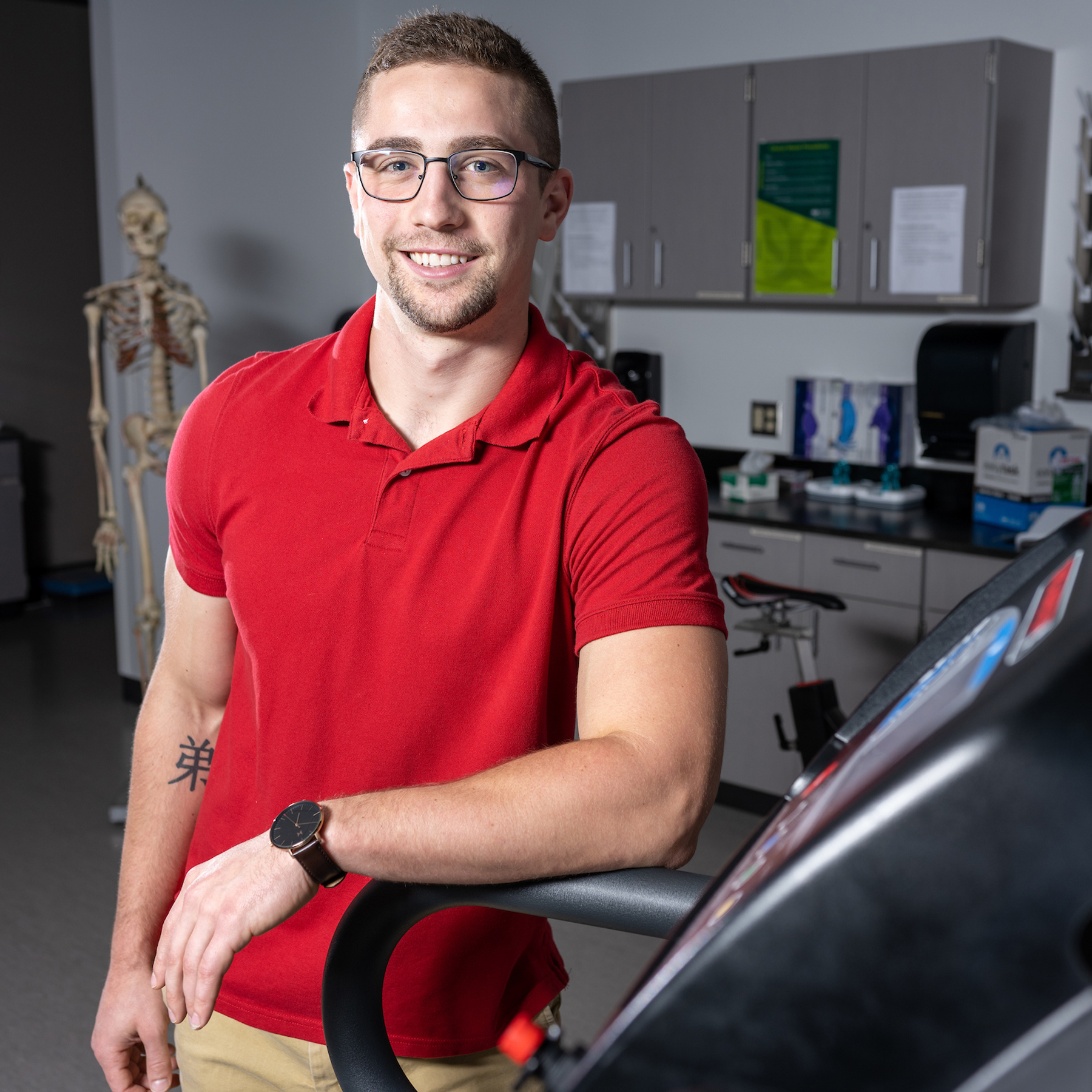 Lane Cullums, alumnus of the Exercise Physiology program, poses in a lab 