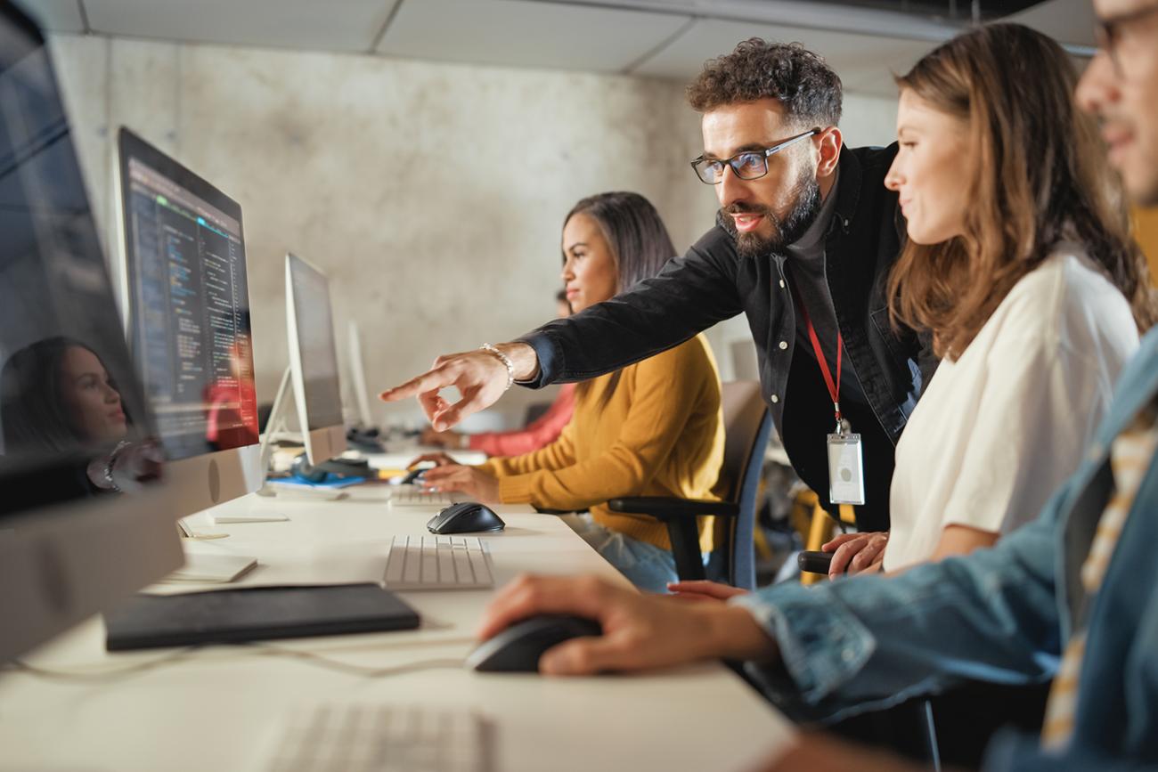 Man points at computer screen in a class setting