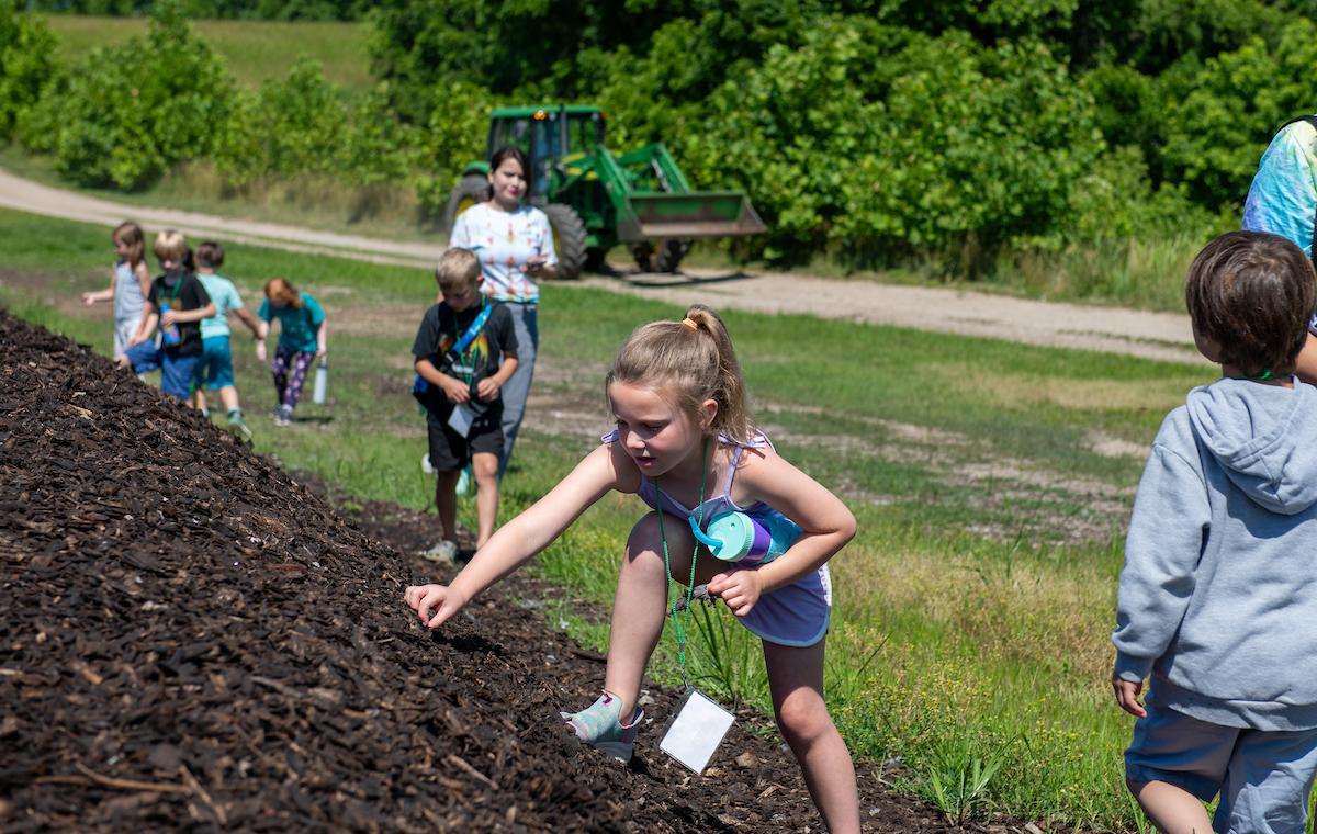 young girl climbing a mulch pile at OHIO's Compost Facility