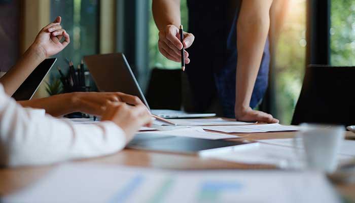 Project managers pointing at paperwork on desk