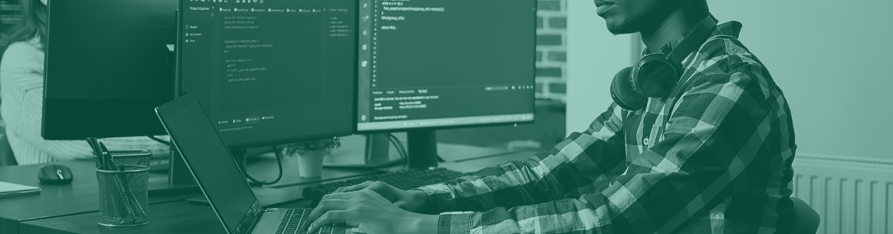 Man working at a desk on coding