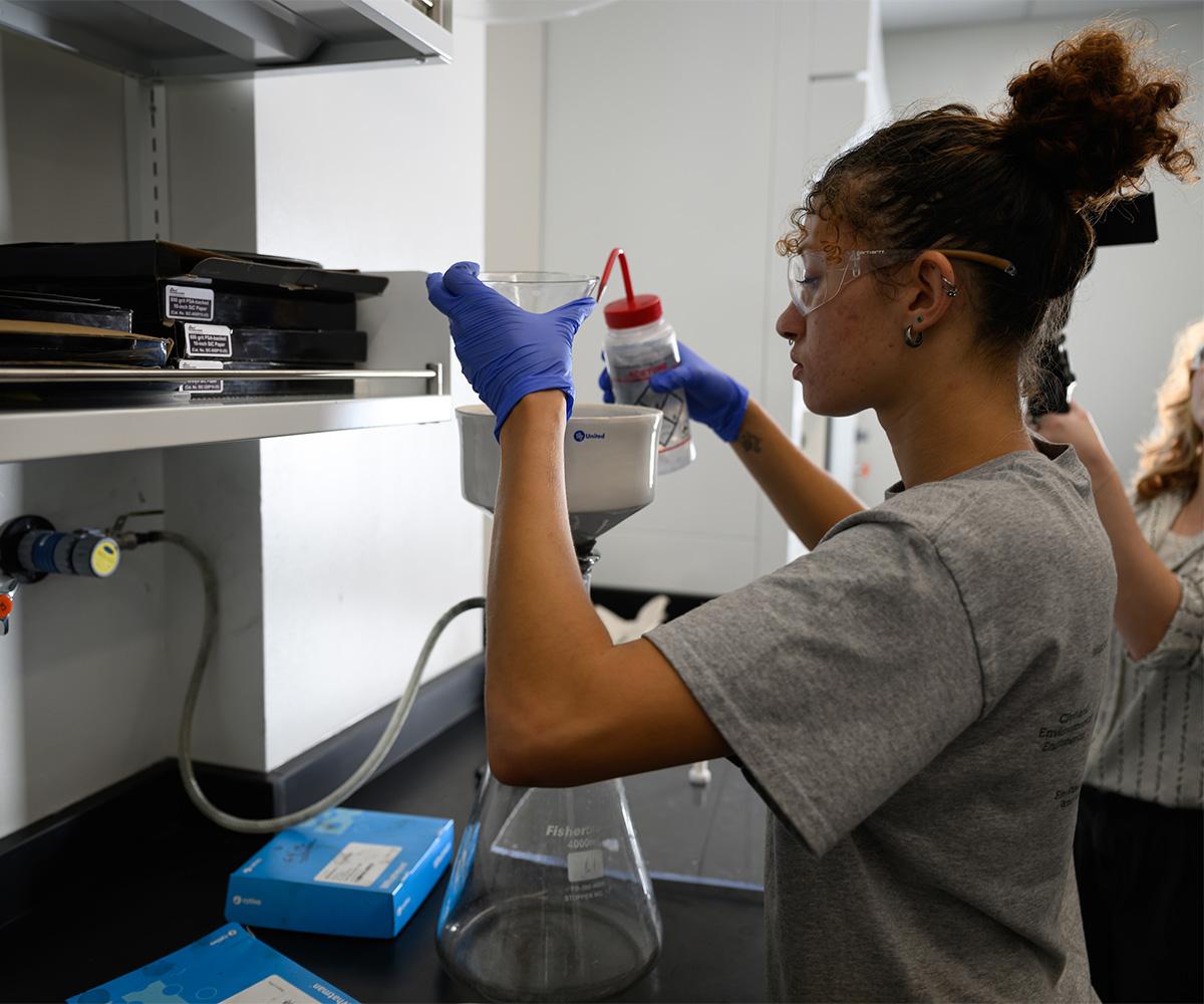 A student works on mixing things in a lab.