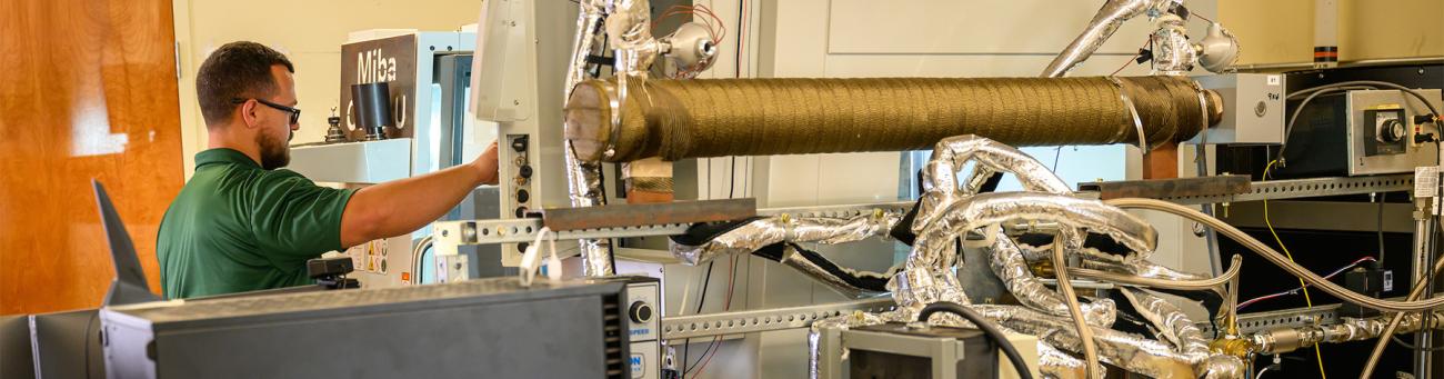 A student works on a machine in a lab.