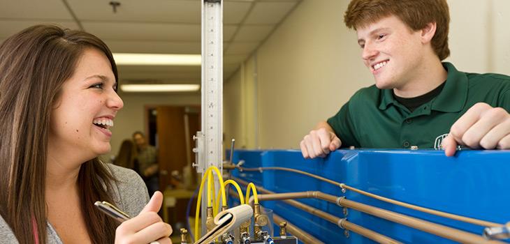 Students working on undergrad project with copper piping.