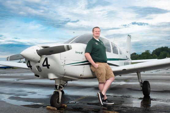 Aviation student poses with an airplane