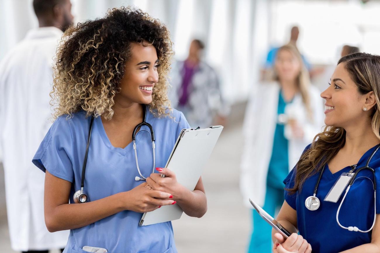 Two nursing colleagues chatting in hospital hallway