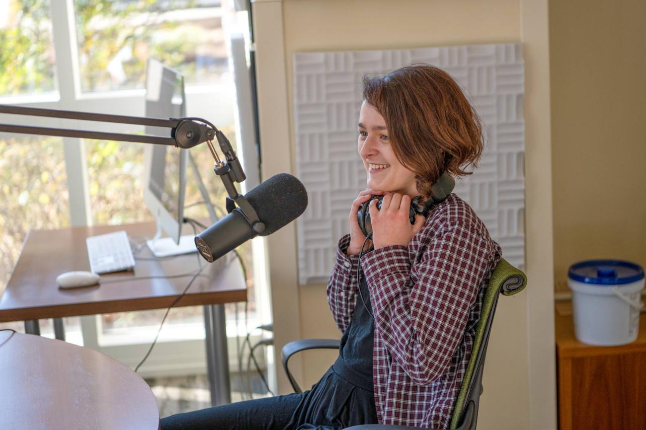 Student journalist sitting behind a microphone setup