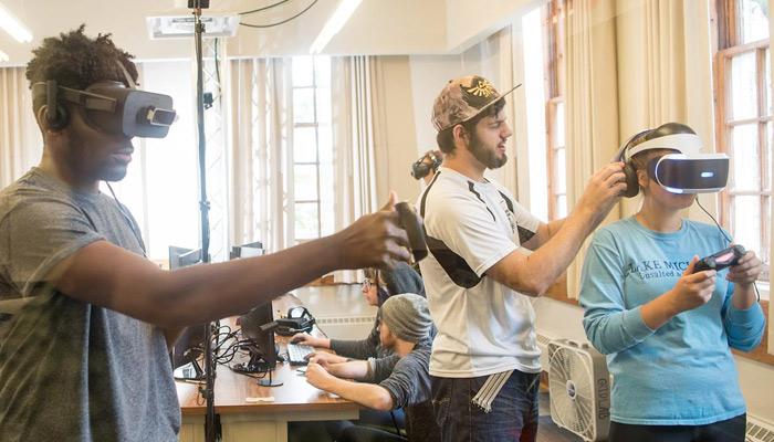 Three students using and testing VR equipment in the GRID Lab