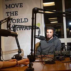 Person sitting in a podcasting room with microphones