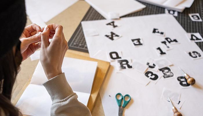 A student working with cut-out letters for a project