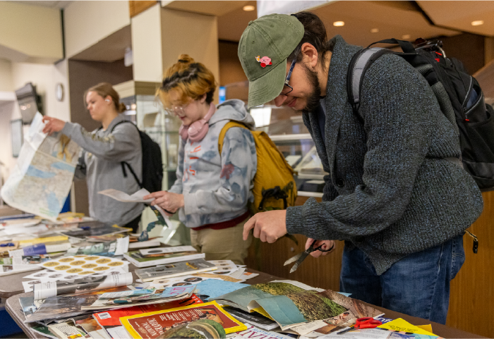 OU Students digging through old magazines for images to turn into buttons at Alden Library