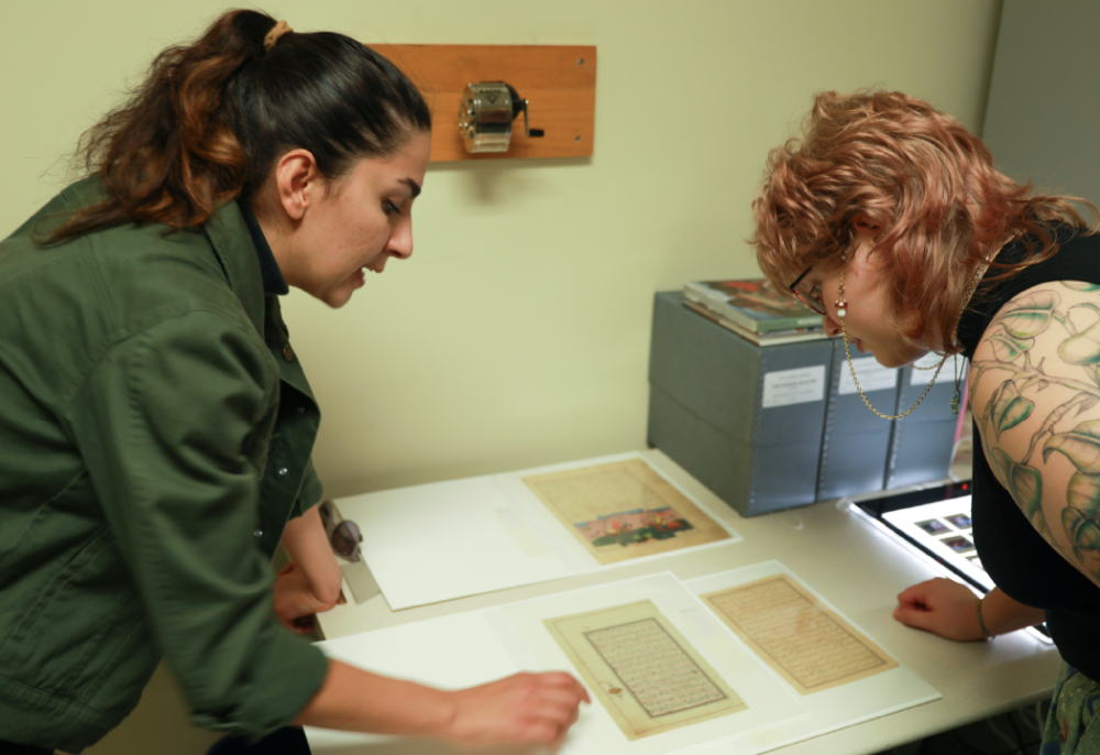 Two students reviewing documents from the archives.