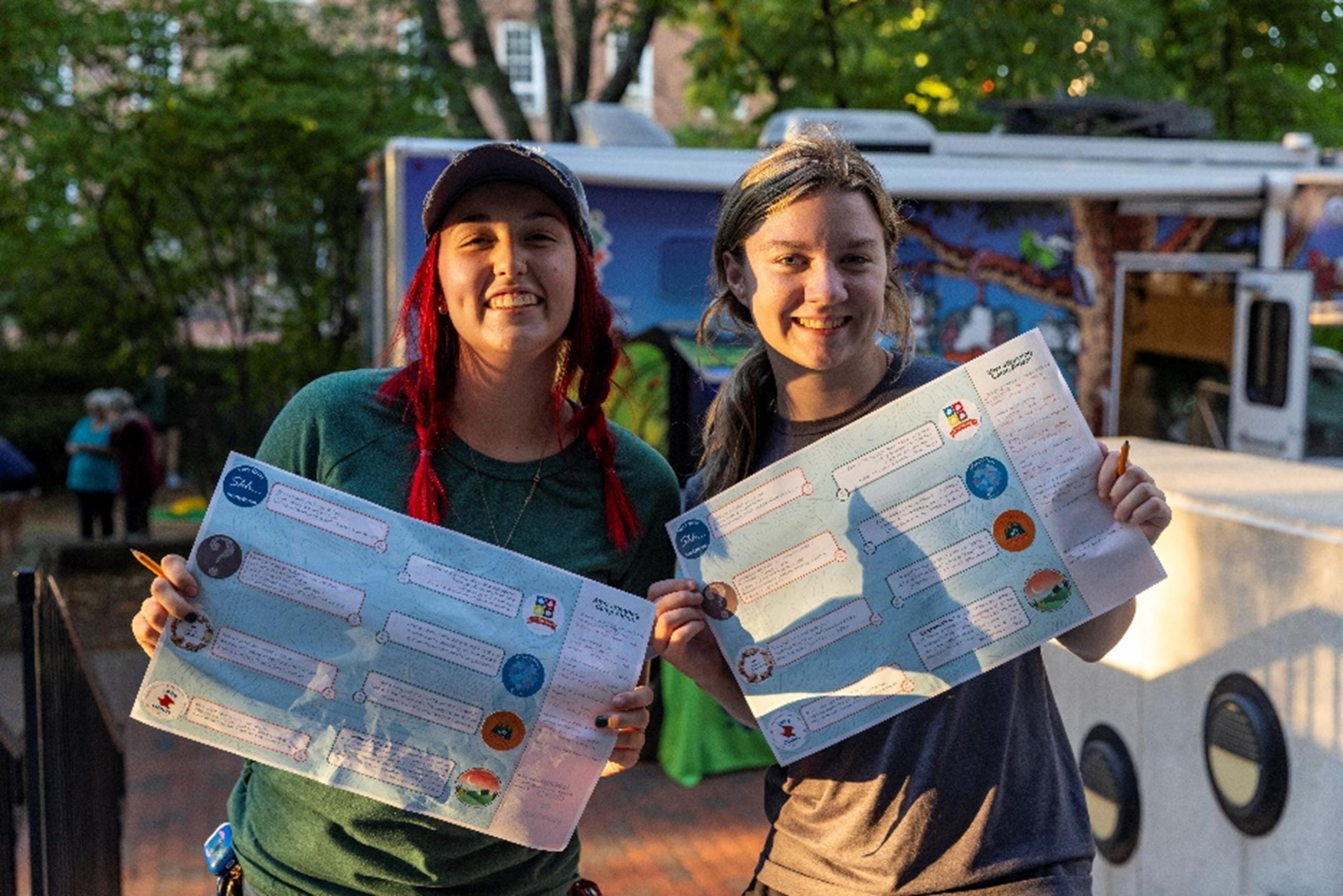 Picture of students holding up their completed scavenger hunt sheets 