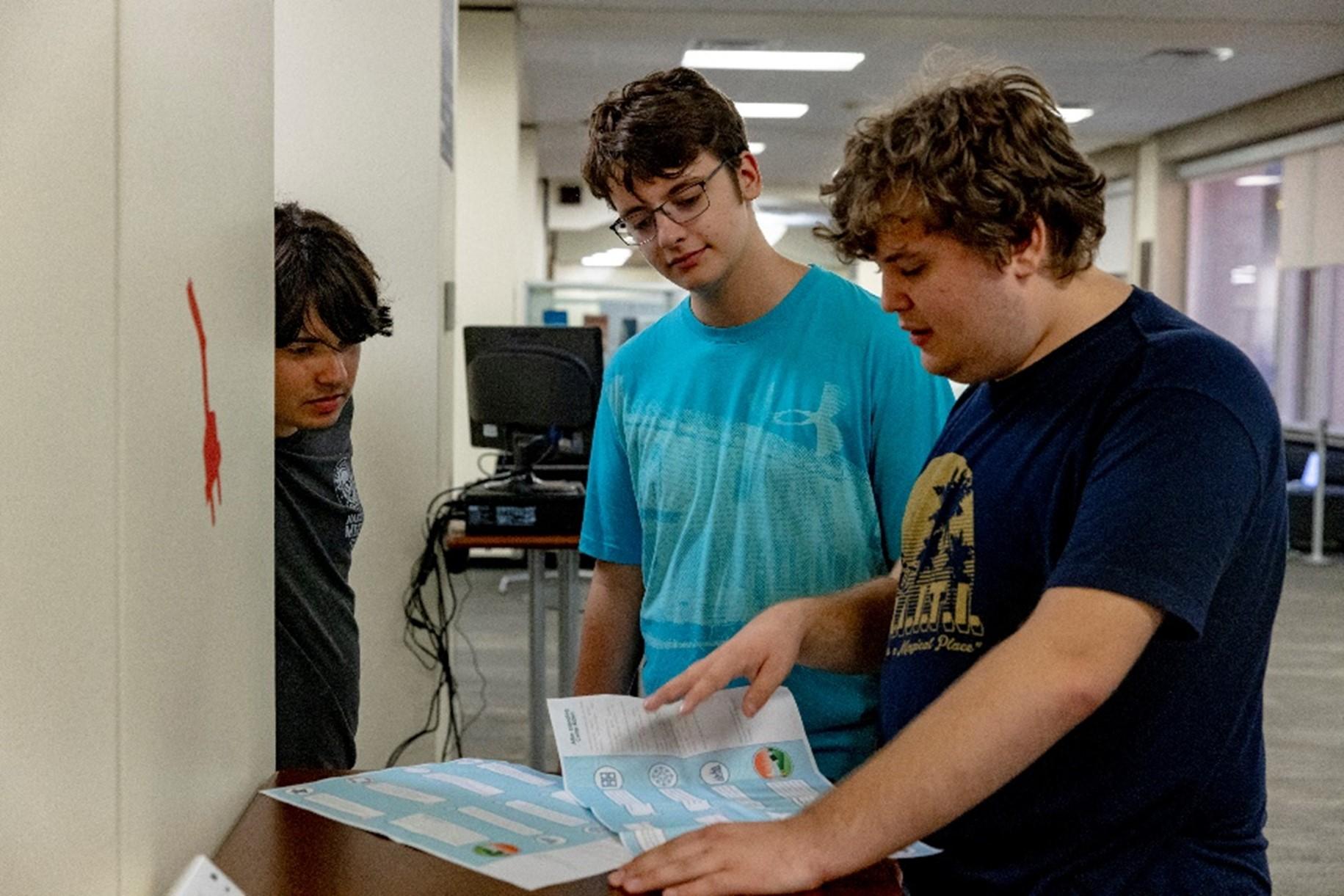 Picture of three students trying to follow clues during the scavenger hunt 