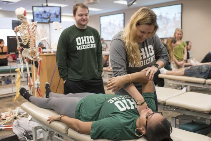 Medical students practice osteopathic manipulative medicine techniques in OMM lab. 