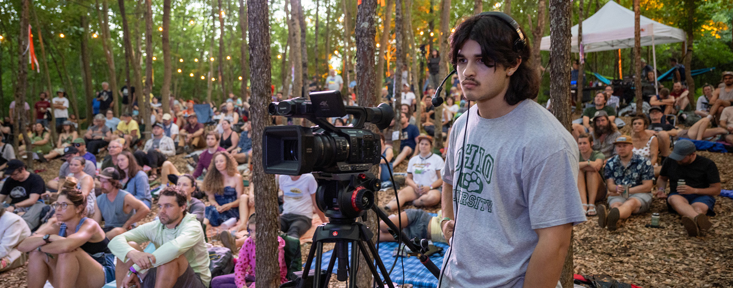 Student operating a camera at the Creekside Stage of Nelsonville Music Festival