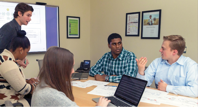 ITS students meeting around a table.