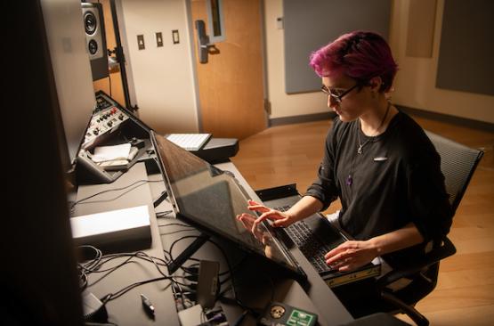 Student uses sound equipment in OHIO's sound mixing and mastering studio